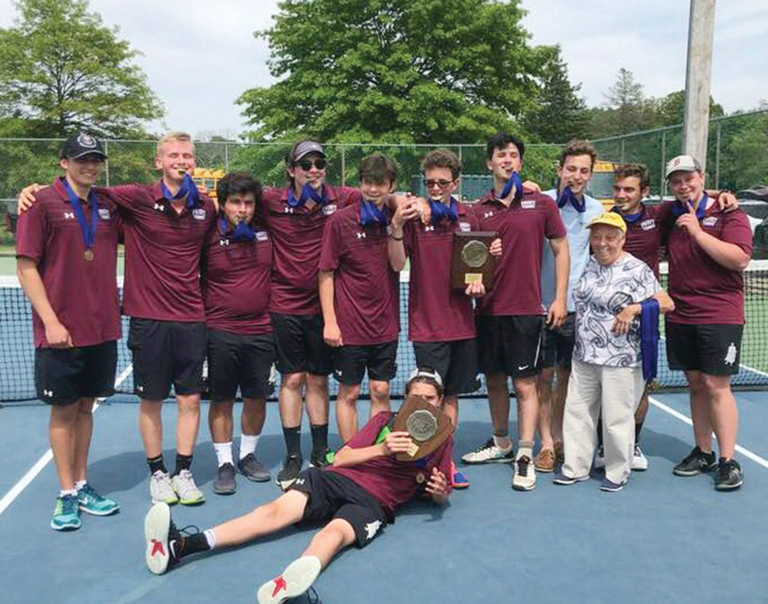 Coach Mary Lou Morissette, third from right, with The Prout School’s 2018 championship boys’ tennis team at Slater Park.